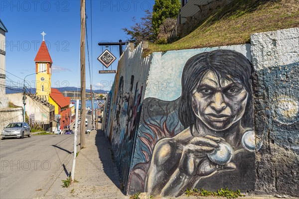 Wall with street art in front of a historic, yellow-red church, Ushuaia, Tierra del Fuego Island, Patagonia, Argentina, South America
