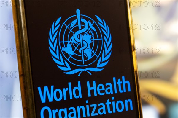 Symbolic image: Smartphone with WHO (World Health Organisation) logo against a blurred background