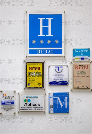 Various hotel and tourism related signs on white wall background, Hotel La Vinuela, Axarquia, Andalusia, Spain, Europe
