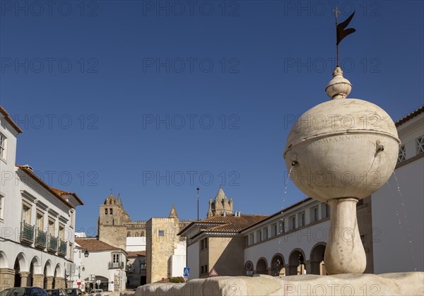 Fountain in the Largo das Portas de Moura with a view to the cathedral and surrounding historic buildings in the city centre of Evora, Alto Alentejo, Portugal, Southern Europe, 23 March 2019, Europe