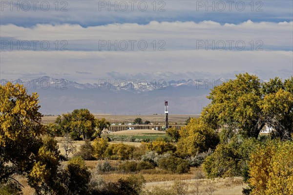 Keenesburg, Colorado, An oil drilling rig on the eastern plains of rural Colorado. The Rocky Mountains are in the distance