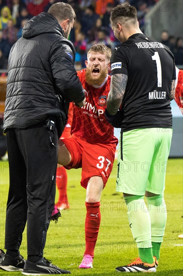 Football match, physiotherapist Marc WEISS 1.FC Heidenheim left and goalkeeper Kevin MUeLLER 1.FC Heidenheim right look after the injured Jan-Niklas BESTE 1.FC Heidenheim, football stadium Voith-Arena, Heidenheim