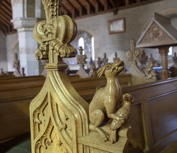 Carved pew bench ends inside All Saints church, Hollesley, Suffolk, England, UK