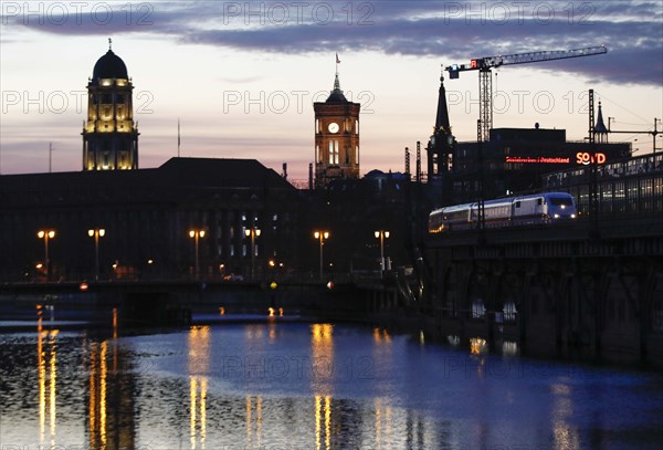 City view Berlin in the evening. View across the Spree to the television tower and the red town hall, a Deutsche Bahn ICE at the S-Bahn station at Janowitzbruecke, 29/03/2021