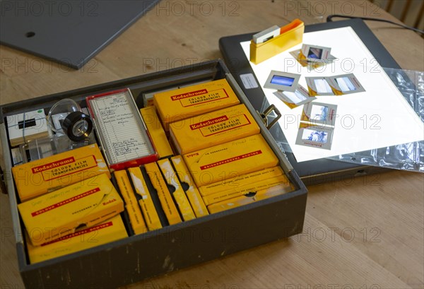 Yellow films storage boxes holding Kodachrome vintage transparency slides dating from 1960s with Lightbox for editing images