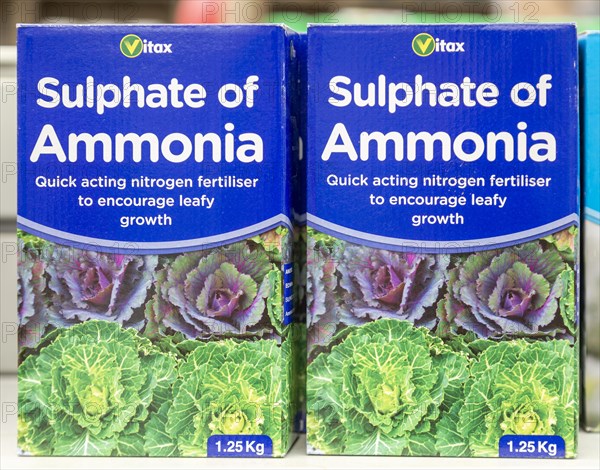 Cardboard boxes of Vitax Sulphate of Ammonia on shelf display in garden centre, UK