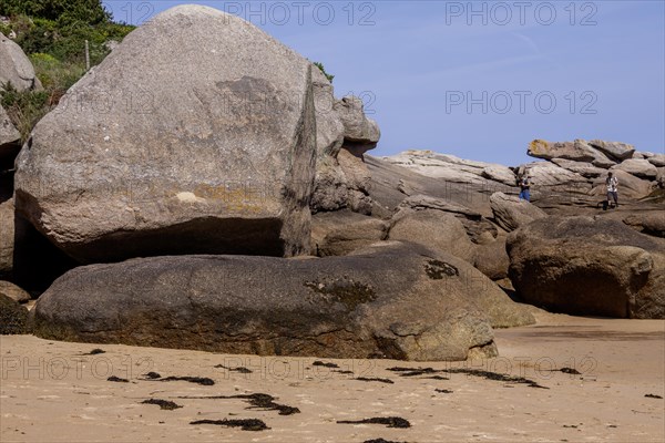 Tourists climbing in the rocks at the Cote de Granit Rose, Departement Cotes-d'Armor, Brittany, France, Europe