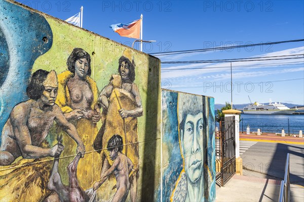 Wall of street art with images of the indigenous Yaghan people, behind a cruise ship in the harbour, Ushuaia, Tierra del Fuego Island, Patagonia, Argentina, South America