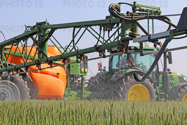 A farmer from the Schmitt vegetable farm in Hockenheim drives his tractor with a crop protection sprayer over his wheat field to combat brown rust and mildew (Hockenheim, Baden-Wuerttemberg)