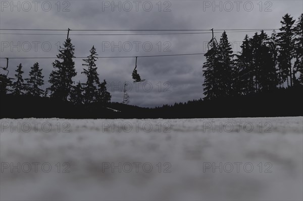 Skiers ride a chairlift, taken on a ski slope in the Jizera Mountains ski area near Albrechtice v Jizerskych Horach, 05.02.2024. The Czech low mountain range with its ski area is affected by increasingly warmer and shorter winters