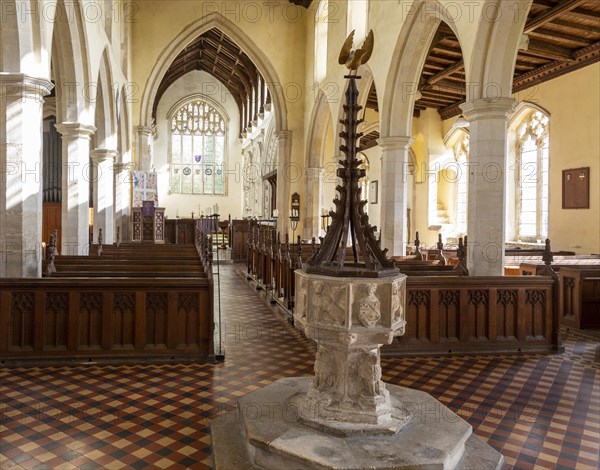 Interior historic village parish church, Wingfield, Suffolk, England, UK baptismal font and nave view to chancel arch, altar and east window