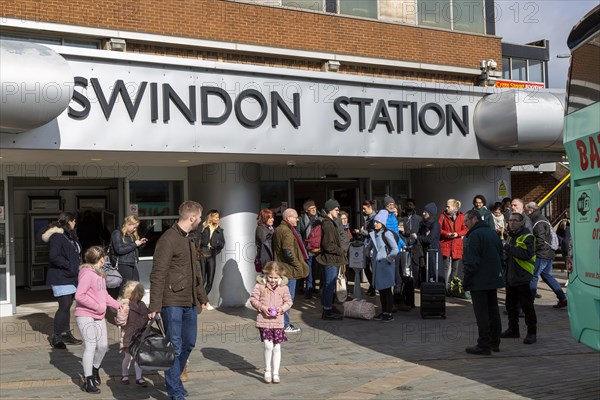 People at railway station waiting for rail replacement bus service, Swindon, Wiltshire, England, UK