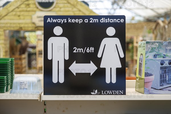 Social Distancing 2 metres apart information notice sign in Lowden garden centre shop, Wiltshire, England, UK, May 2020