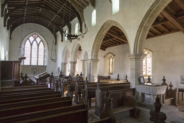 Interior of historic wooden pews, wooden roof beams, whitewashed walls and columns, All Saints church, South Elmham, Suffolk, England, UK, church in In the care of the Churches Conservation Trust