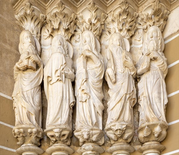 Historic Roman Catholic cathedral church of Evora, Se de Evora, in the city centre, Basilica Cathedral of Our Lady of Assumption. This image shows details of the carved Gothic period Apostles in the main doorway entrance. Marble columns are occupied by huge statues of the Apostles dating from the 1330s