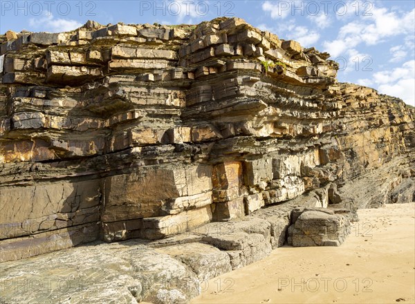 Tilted layers showing bedding planes in strata of sedimentary rock in coastal cliff at Odeceixe, Algarve, Portugal, Southern Europe. Differential erosion is evident due to different layers of rock having differing resistance to erosive force of the sea. Southwest Alentejo and Vicentina Coast Natural Park 29 March 2019, Europe