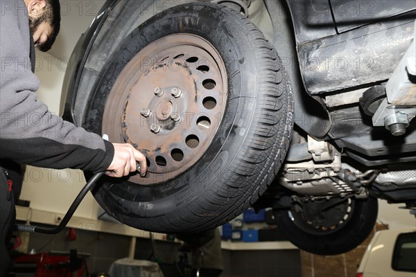 Fitting new all-weather tyres in the garage (editorial)