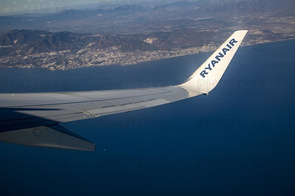 Wing of Ryanair aircraft above Mediterranean Sea over the Costa del Sol taking off from Malaga, Spain, Europe