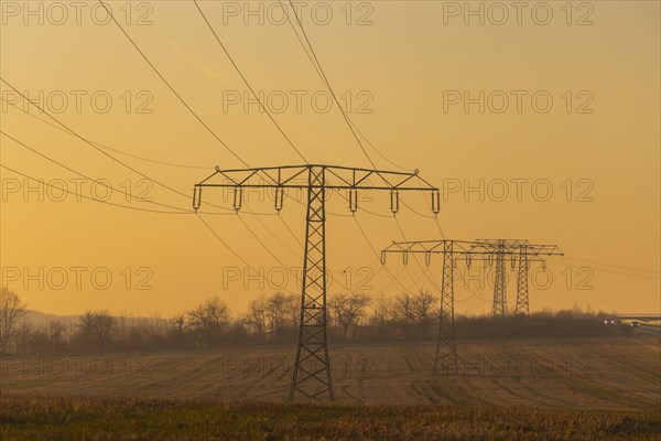Evening light over fields near Krebs in the Osterzgebirge, electricity pylons can be seen graphically, Krebs, Saxony, Germany, Europe