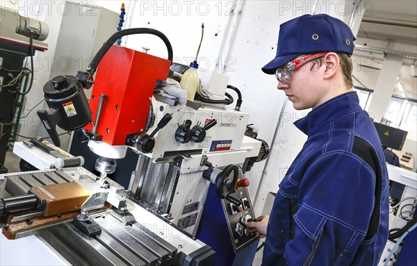 A trainee mechatronics technician works with a bench drill on a workpiece in a Deutsche Bahn training centre, Berlin, 07/02/2024