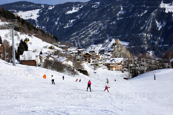 Ladis in winter, the ski piste in the foreground and the village with Laudegg Castle in the background