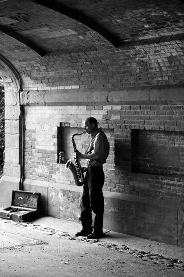 Saxophone player under a bridge in Central Park, New York City, USA, North America