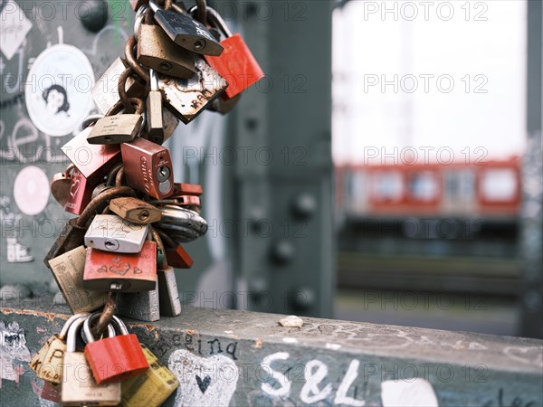 Love locks on a bridge over the Rhine, behind it a railway, blurred background, Cologne, Germany, Europe