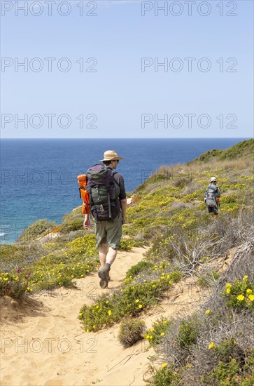 Two people walking the cliff top coastal footpath trail, The Fisherman's Walker or Ruta Vicentina, near Odeceixe, Algarve, Portugal, Southern Europe, Europe