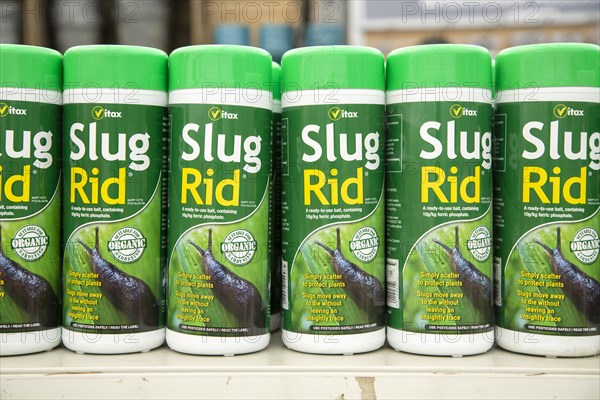 Plastic containers of organic Vitax Slug Rid bait on shelf display in garden centre, UK