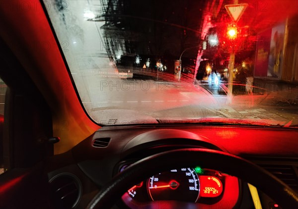 View from the car in dangerously poor visibility at night with rain in front of a red traffic light, Dortmund, Ruhr area, Germany, Europe