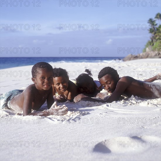 Seychelles, Fregate, local children on the white sandy beach of Anse Victorin, Africa