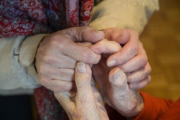 Hands of an old woman are held