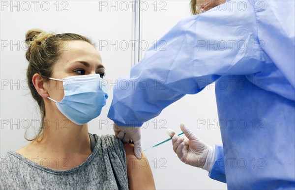A woman receives a vaccination with Covid19 Biontech Pfizer vaccine Comirnaty in a vaccination centre, Schoenefeld, 26.02.2021