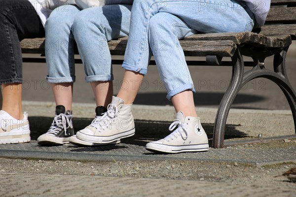 Young woman on a park bench wearing chucks