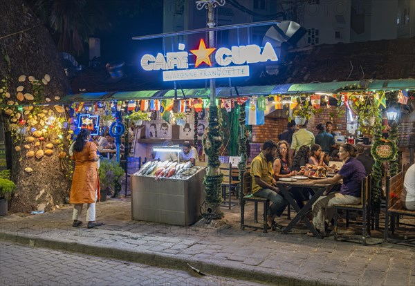 Diners enjoy a lively evening at a street-side restaurant on Tower Road, Fort Kochi, Cochin, Kerala, India, Asia