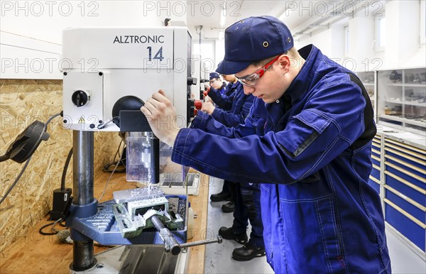 A trainee mechatronics technician works with a bench drill on a workpiece in a Deutsche Bahn training centre, Berlin, 07/02/2024