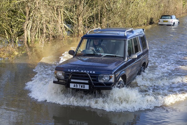Land Rover Discovery Td5 vehicle driving through flood water at Kellaways, Wiltshire, England, UK 24/12/20