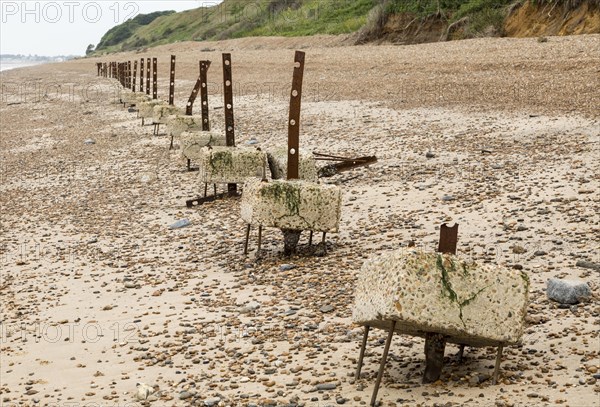 Remains of steel stanchions for barbed wire anti-invasion defences on beach at Bawdsey, Suffolk, England, UK