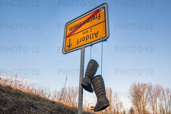 Freimersheim, Palatinate: Upside-down town sign with rubber boots as a symbol of the farmers' protests in Germany
