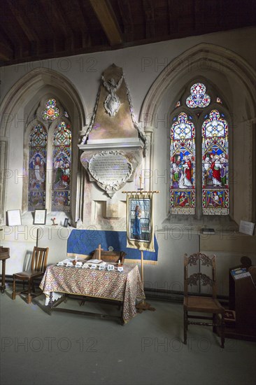 Side chapel altar, stained glass windows inside the church at Urchfont, Wiltshire, England, UK
