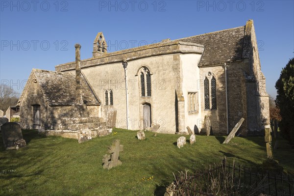 Building exterior historic church of Saint John, Inglesham, Wiltshire, England, UK 13th century building with 15th century churchyard cross