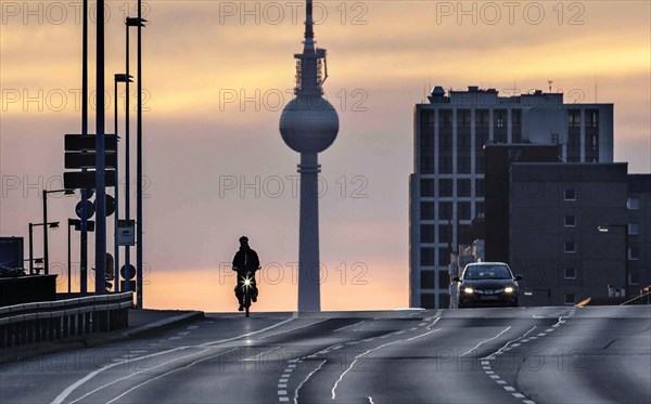 A cyclist and a car driver ride alone on the otherwise busy Frankfurter Allee, Berlin, 29/03/2021