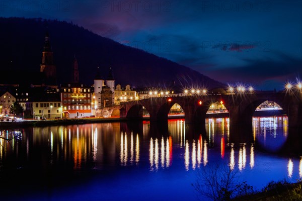 Night shot of Heidelberg. In December 2022, the Old Bridge is unlit with the exception of the streetlights. Other sights such as Heidelberg Castle are also unlit