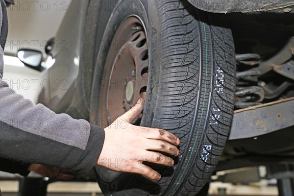 Fitting new all-weather tyres in the garage (editorial)