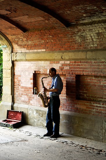 Saxophone player under a bridge in Central Park, New York City, USA, North America