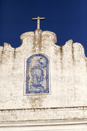 Historic church inside the walled hilltop village of Marvao, Alto Alentejo, Portugal, Azulejo detail on whitewashed wall deep blue sky, Europe