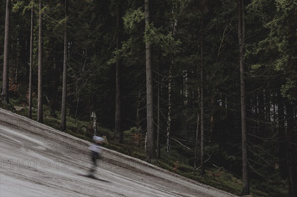 A skier skis on an artificially snow-covered and dirty slope, taken on a ski slope in the Jizera Mountains ski resort near Albrechtice v Jizerskych Horach, 05.02.2024. The Czech low mountain range with its ski resort is affected by increasingly warmer and shorter winters