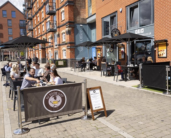 People sitting outside newly reopened cafes on the waterfront, Wet Dock, Ipswich, Suffolk, England, UK July 2020