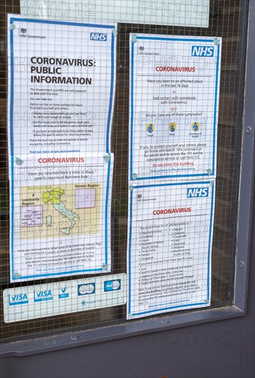 National Health Service NHS government information Coronavirus notice glass door entrance to GP surgery, Alderton, Suffolk, England, UK, -15 March 2020