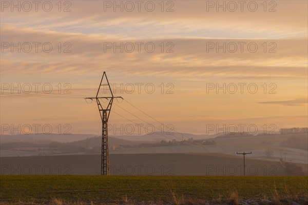 Evening light over fields near Krebs in the Osterzgebirge, electricity pylons can be seen graphically, Krebs, Saxony, Germany, Europe